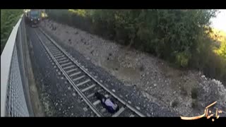 این جوان زیر قطار در حال عبور می خوابد